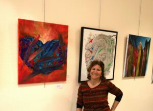L'exposante devant ses toiles